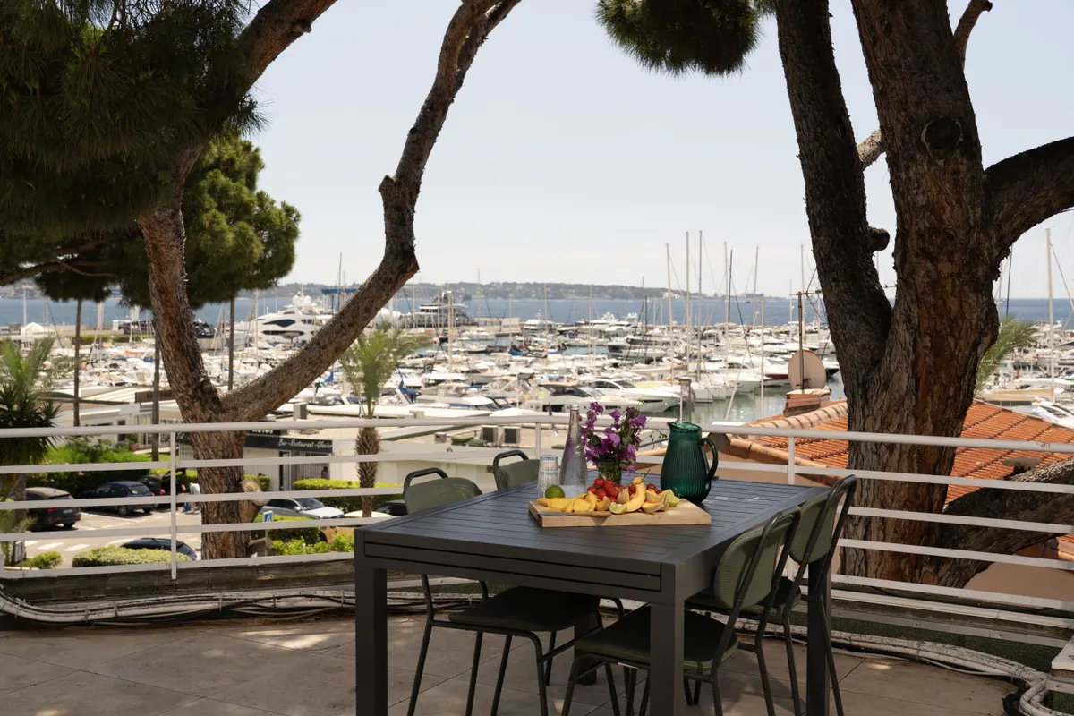 Dining and seating areas share the roof terrace beneath mature pines.